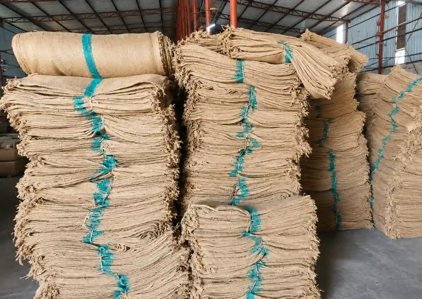 jute fabric bundles stacked in warehouse